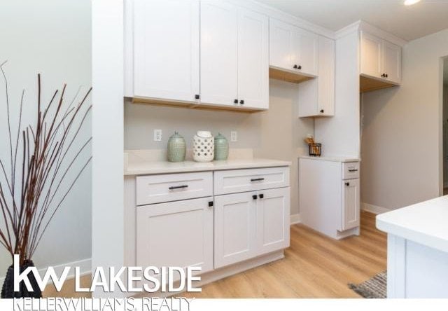 kitchen with white cabinets and light hardwood / wood-style flooring