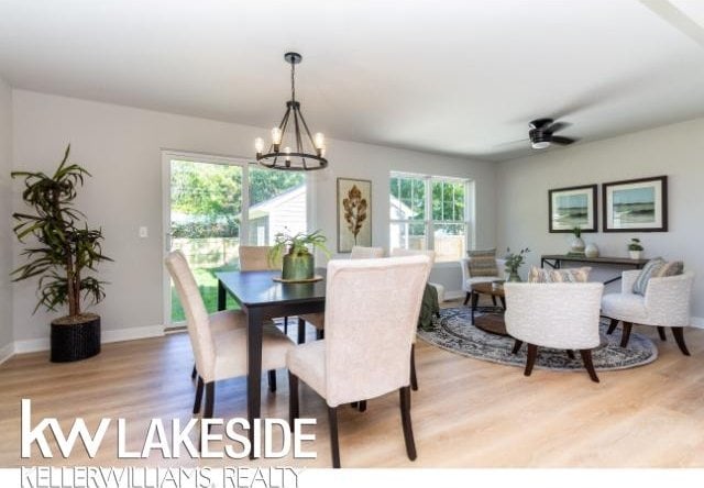 dining room with ceiling fan with notable chandelier and light wood-type flooring