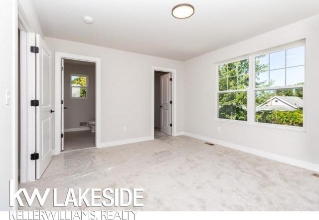 unfurnished bedroom with light colored carpet