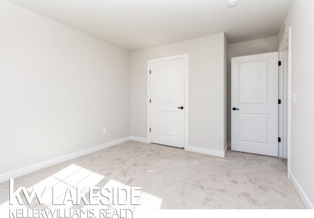 unfurnished bedroom featuring light carpet