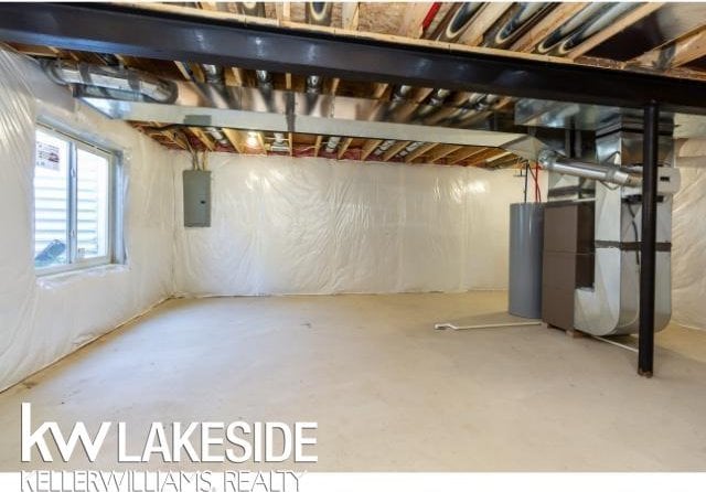 basement with heating unit, electric panel, and water heater