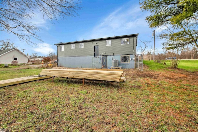 rear view of property featuring a lawn