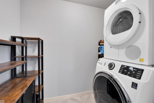 clothes washing area featuring stacked washing maching and dryer