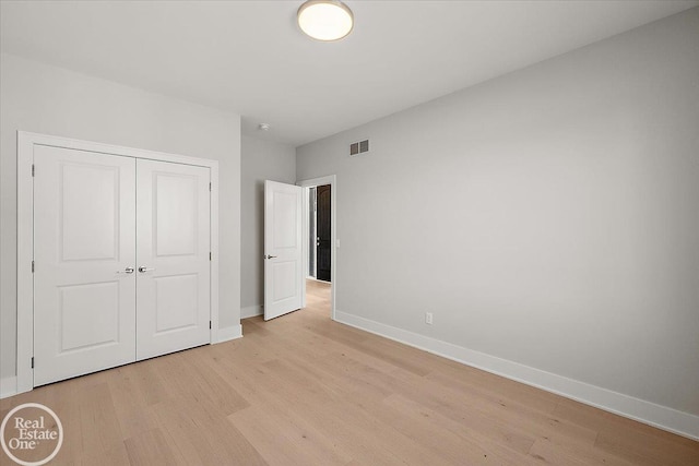 unfurnished bedroom featuring light wood-type flooring and a closet