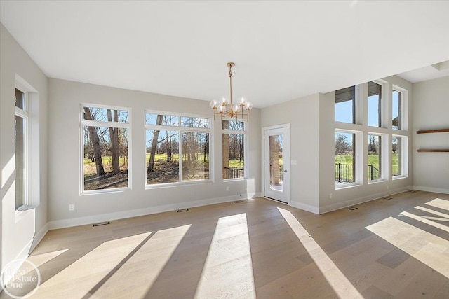 unfurnished sunroom featuring a notable chandelier and a wealth of natural light