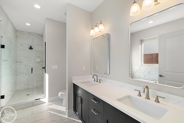 bathroom with a shower with door, vanity, and toilet