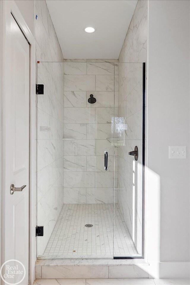 bathroom featuring a shower with door