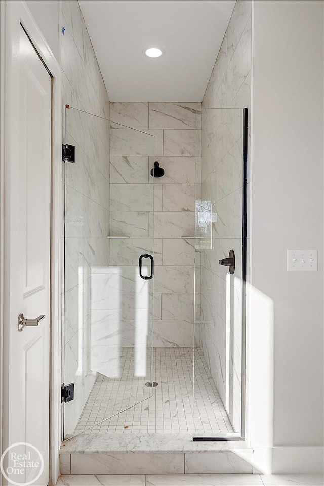 bathroom with a shower with door