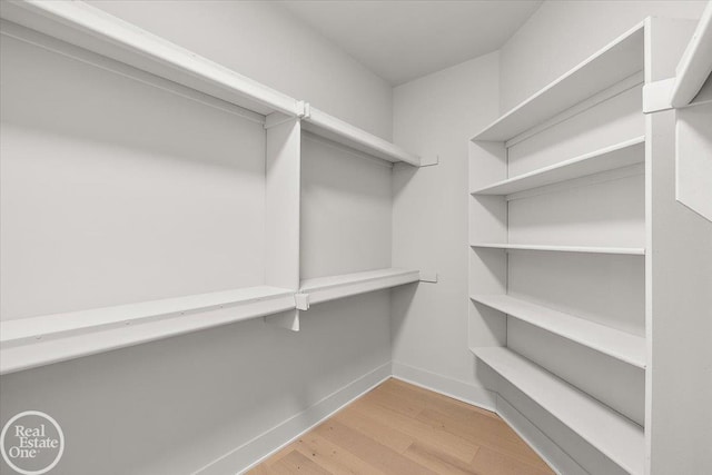 spacious closet with light hardwood / wood-style flooring