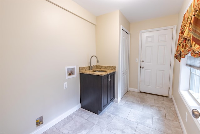 clothes washing area featuring cabinets, washer hookup, and sink