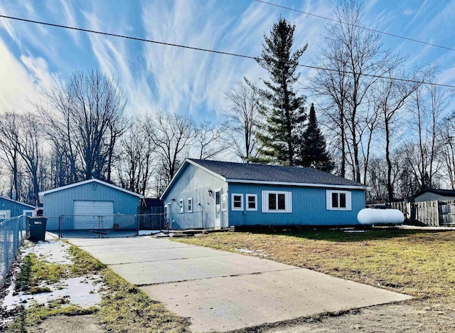 ranch-style home featuring a garage, an outbuilding, and a front lawn