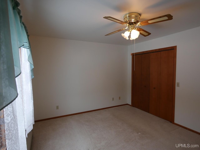 unfurnished bedroom with ceiling fan, a closet, and light colored carpet