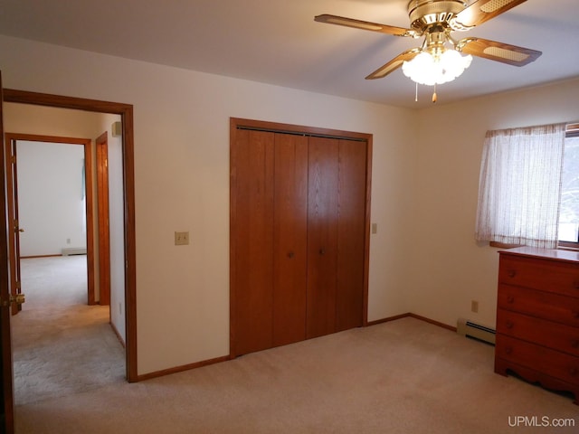 unfurnished bedroom featuring light carpet, a closet, a baseboard radiator, and ceiling fan