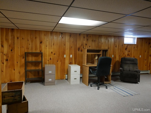 office area with a paneled ceiling, carpet floors, baseboard heating, and wooden walls