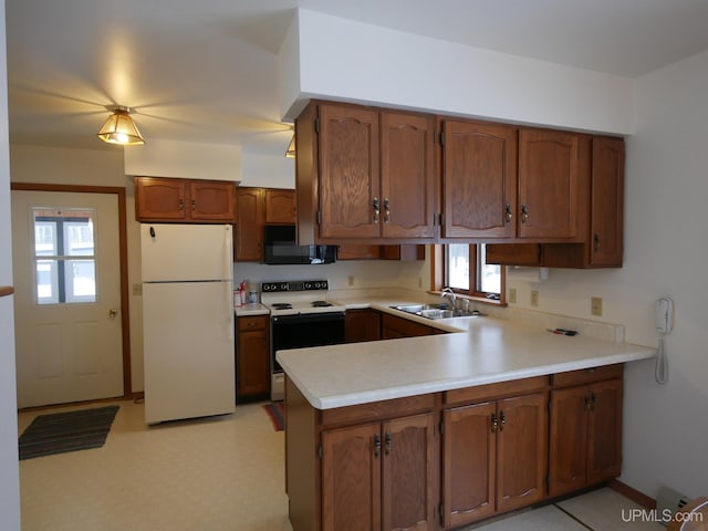 kitchen with kitchen peninsula, sink, and white appliances