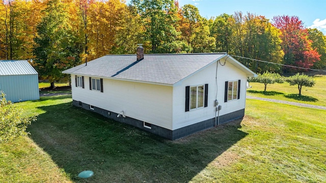 view of home's exterior featuring a lawn and a storage unit