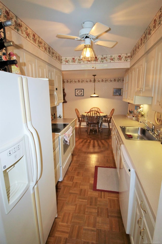 kitchen with white appliances, dark parquet floors, ceiling fan, sink, and decorative light fixtures