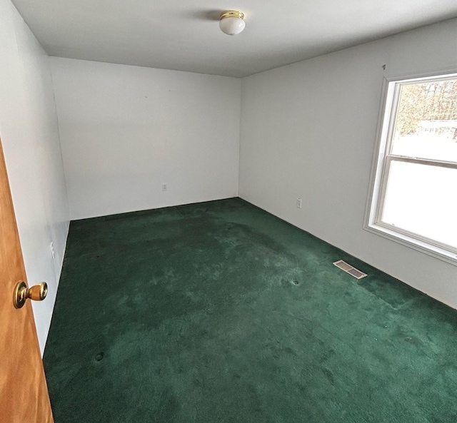 spare room featuring dark carpet