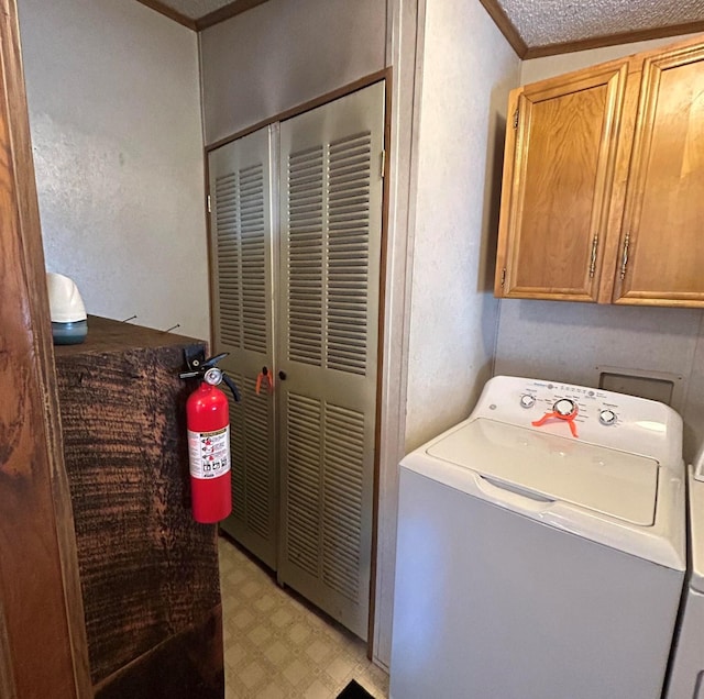 laundry room with washer / clothes dryer, cabinets, a textured ceiling, and ornamental molding