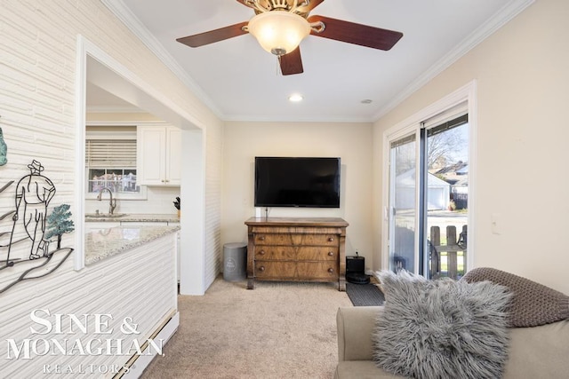 living room with sink, ornamental molding, and light carpet