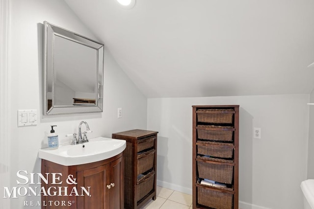 bathroom with tile patterned floors, vanity, and vaulted ceiling