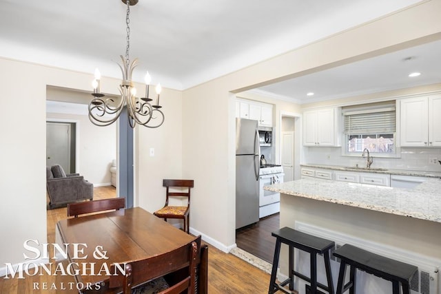 dining space with a notable chandelier, dark hardwood / wood-style flooring, and sink