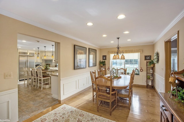 dining room featuring light hardwood / wood-style floors, an inviting chandelier, and crown molding