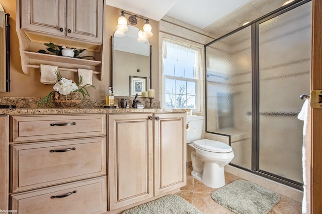 bathroom with toilet, vanity, tile patterned floors, and a shower with door