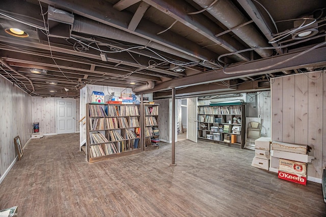 basement with wood-type flooring and wooden walls