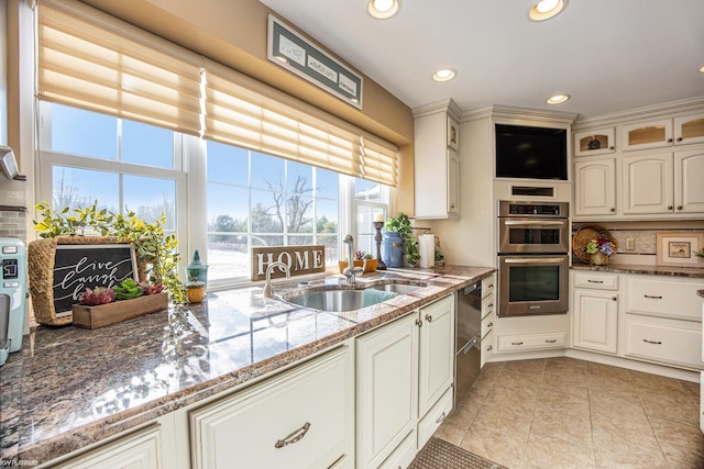 kitchen with stainless steel double oven, white cabinetry, and dark stone countertops