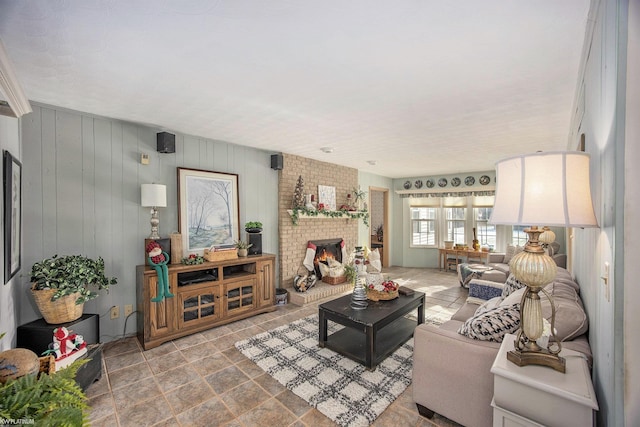 living room featuring a brick fireplace and wood walls