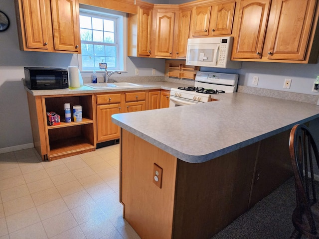 kitchen with kitchen peninsula, white appliances, and sink