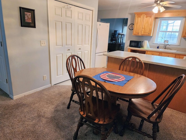 carpeted dining space with ceiling fan and sink