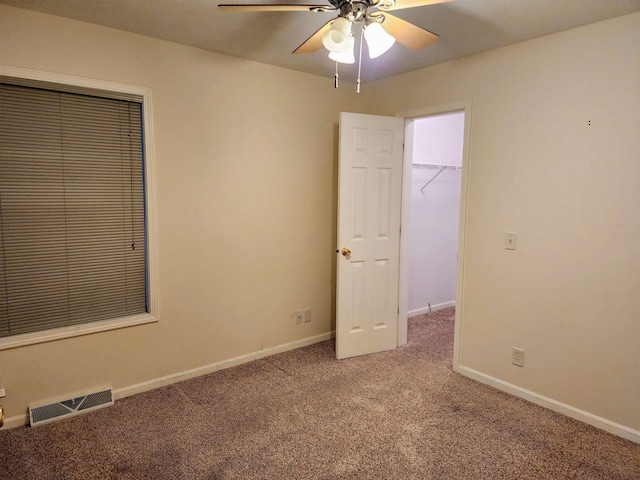 carpeted spare room with ceiling fan