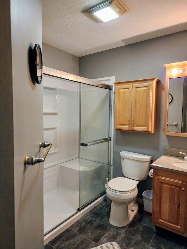 bathroom featuring walk in shower, tile patterned floors, a textured ceiling, toilet, and vanity