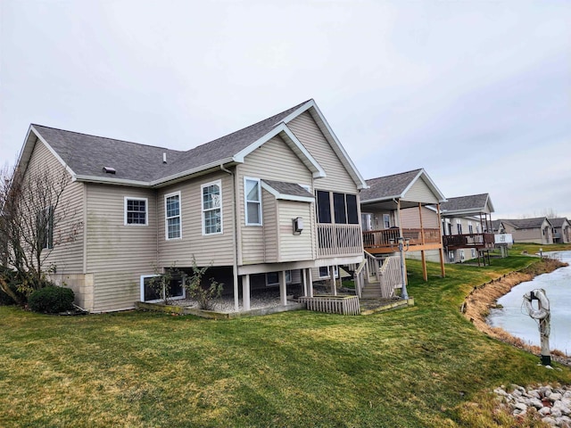 rear view of property with a wooden deck and a lawn