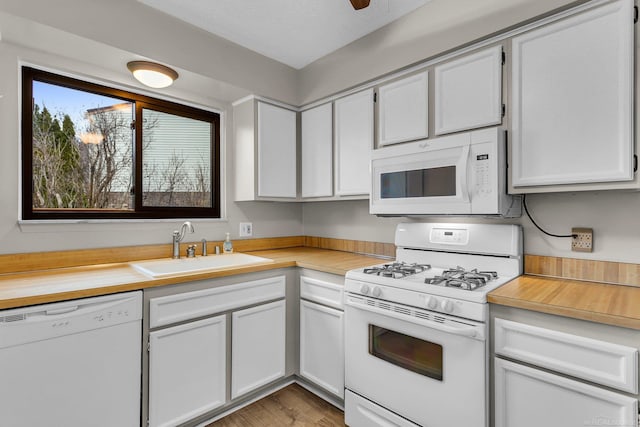 kitchen featuring white cabinetry, sink, light hardwood / wood-style floors, and white appliances