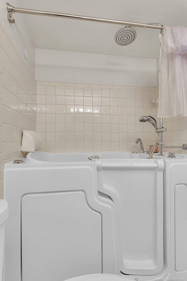 bathroom with backsplash and tile walls