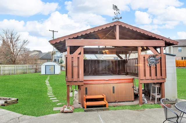 exterior space with a patio, a yard, a hot tub, and a storage unit