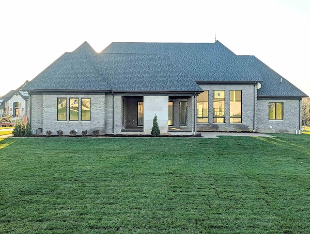 rear view of property featuring a lawn