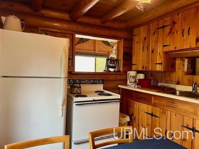 kitchen featuring beam ceiling, rustic walls, sink, white appliances, and wood ceiling