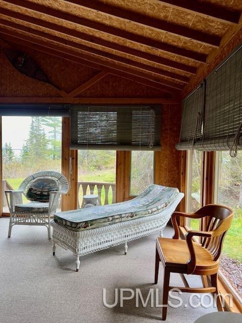 sunroom / solarium featuring lofted ceiling with beams