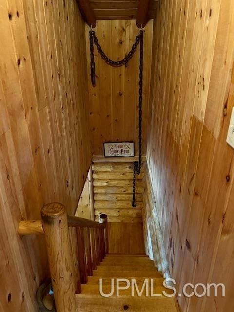 stairs with hardwood / wood-style floors and wood walls