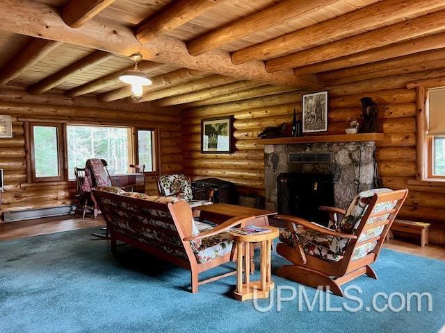 living area with a wealth of natural light, hardwood / wood-style floors, and log walls