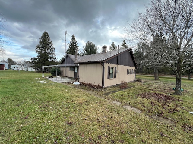 view of side of home with a yard and a patio