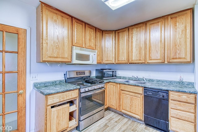 kitchen with sink, stainless steel appliances, and light wood-type flooring