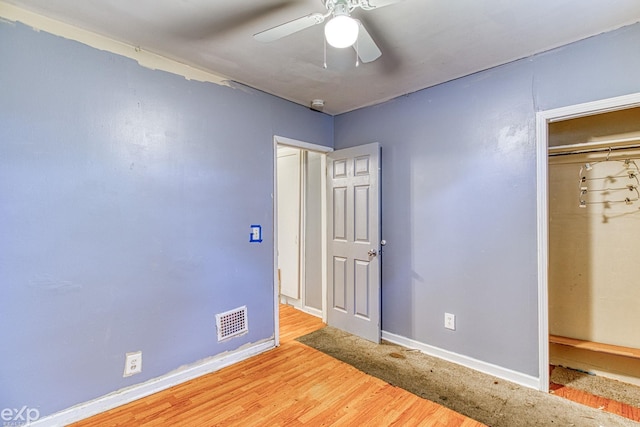 unfurnished bedroom featuring a closet, light hardwood / wood-style flooring, and ceiling fan