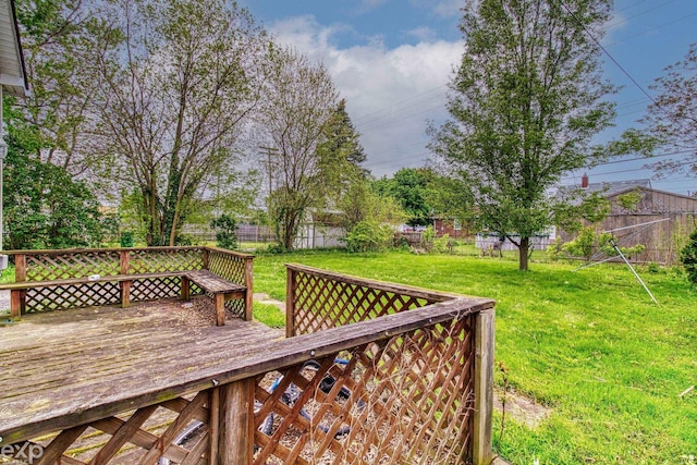 wooden deck featuring a lawn