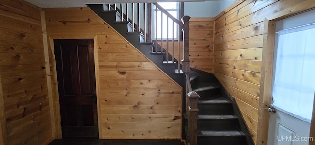 staircase featuring wood walls