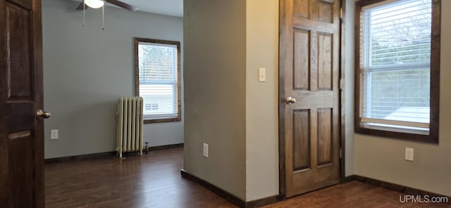 entrance foyer with ceiling fan, dark wood-type flooring, and radiator